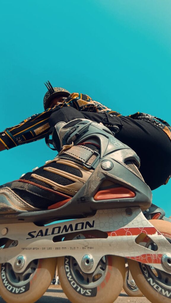 Exciting low angle view of a skater in action, showcasing dynamic movement against a clear sky.